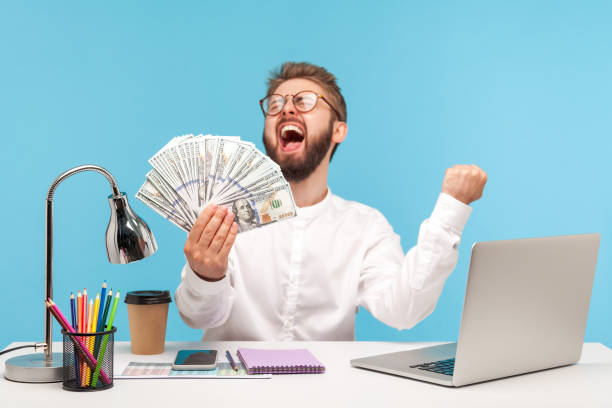 Person working on laptop with dollar signs and Money Makers